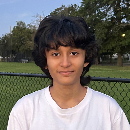 I am Yudh. I am wearing a white shirt outdoors and smiling into the camera.