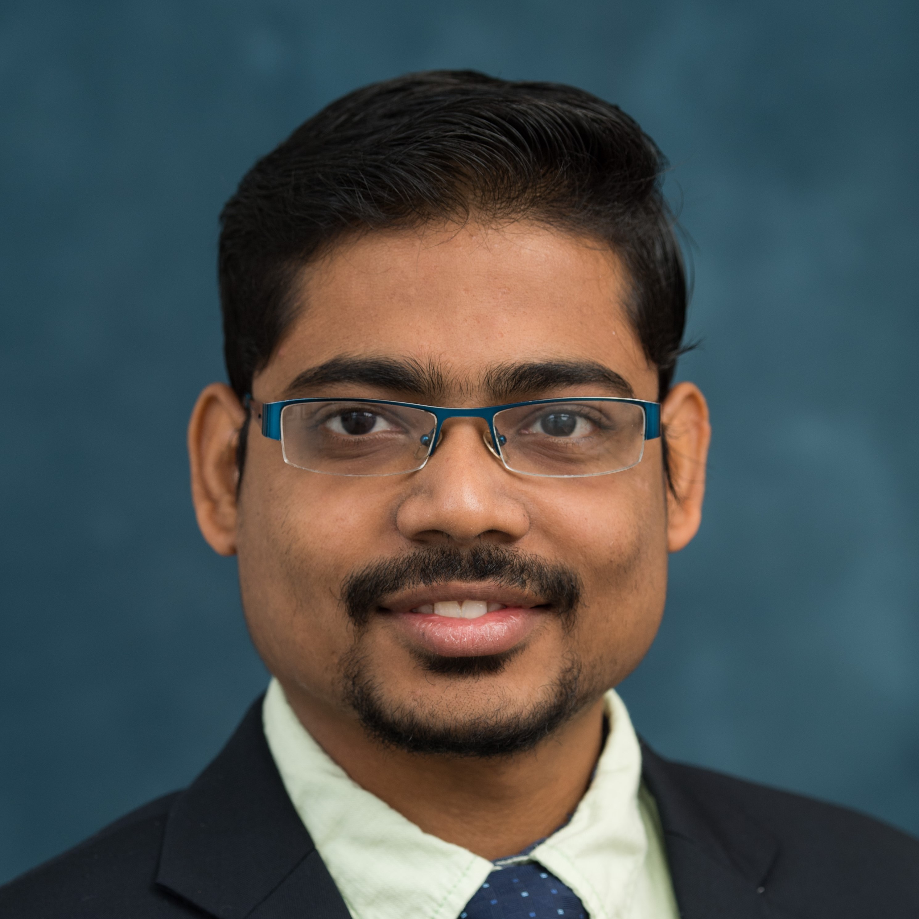 I am Suresh. In this headshot I’m wearing a green casual shirt and a dark blue blazer. I’m smiling at the camera